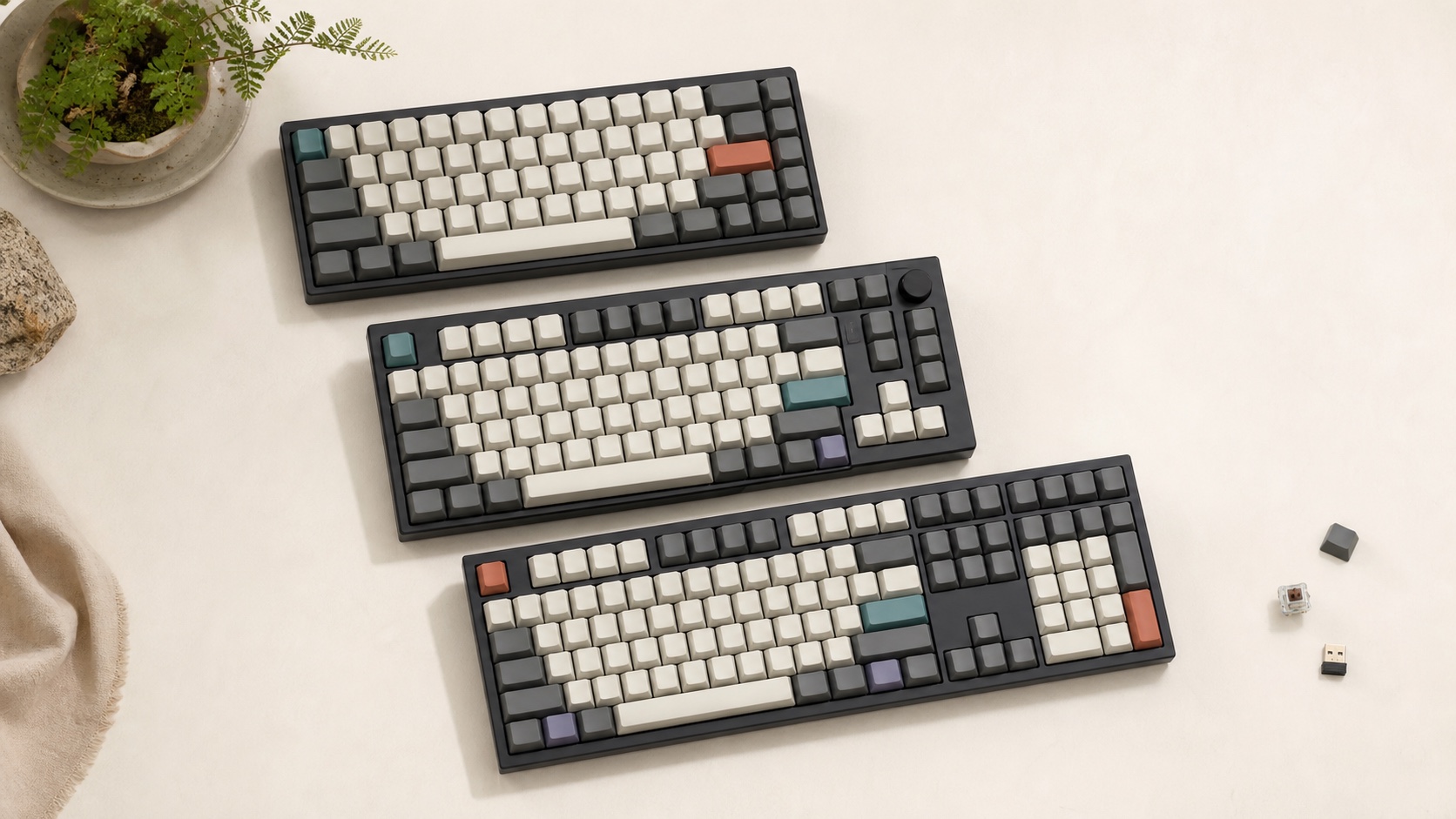 サイズの異なる三台のキーボードとスイッチ、キーキャップ、無線レシーバーを並べた購入前確認のコンセプトビジュアル